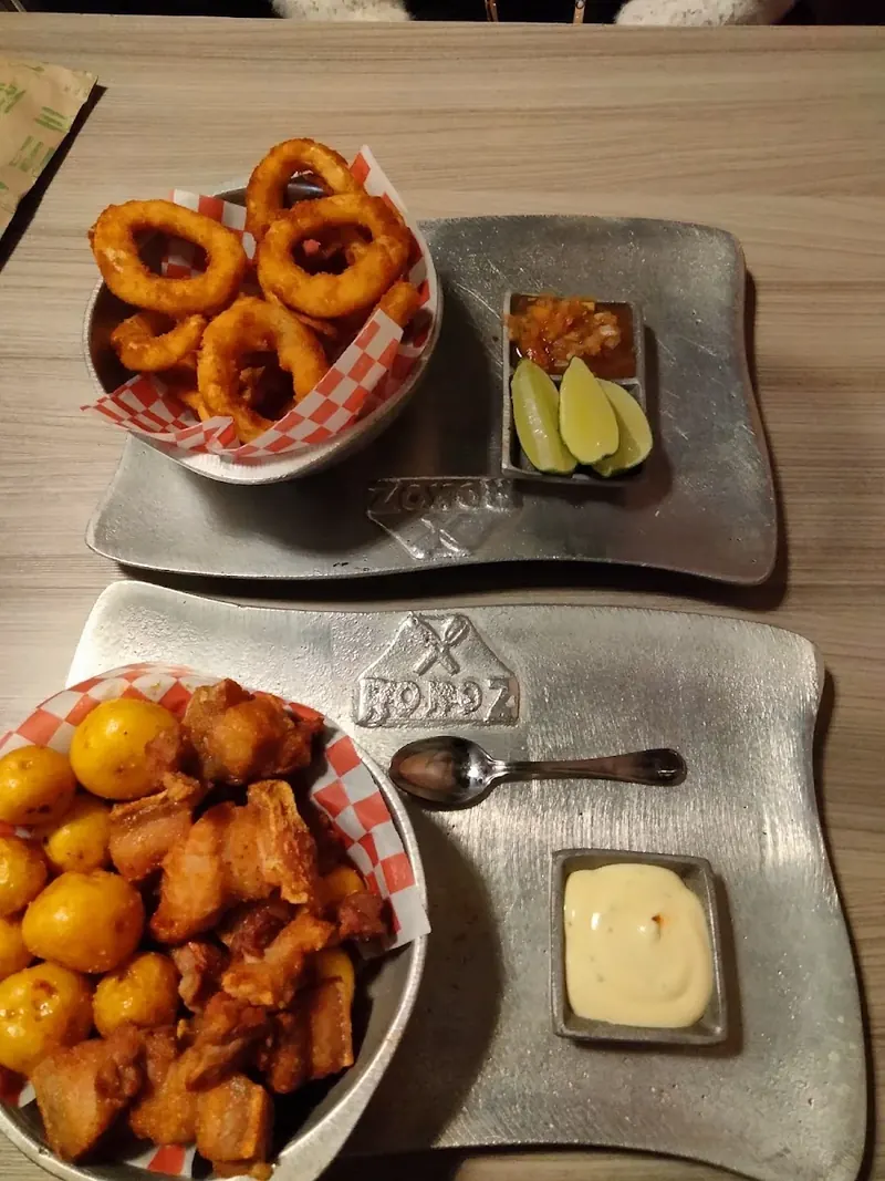 Aros de cebolla y papas criollas servidos como entrada